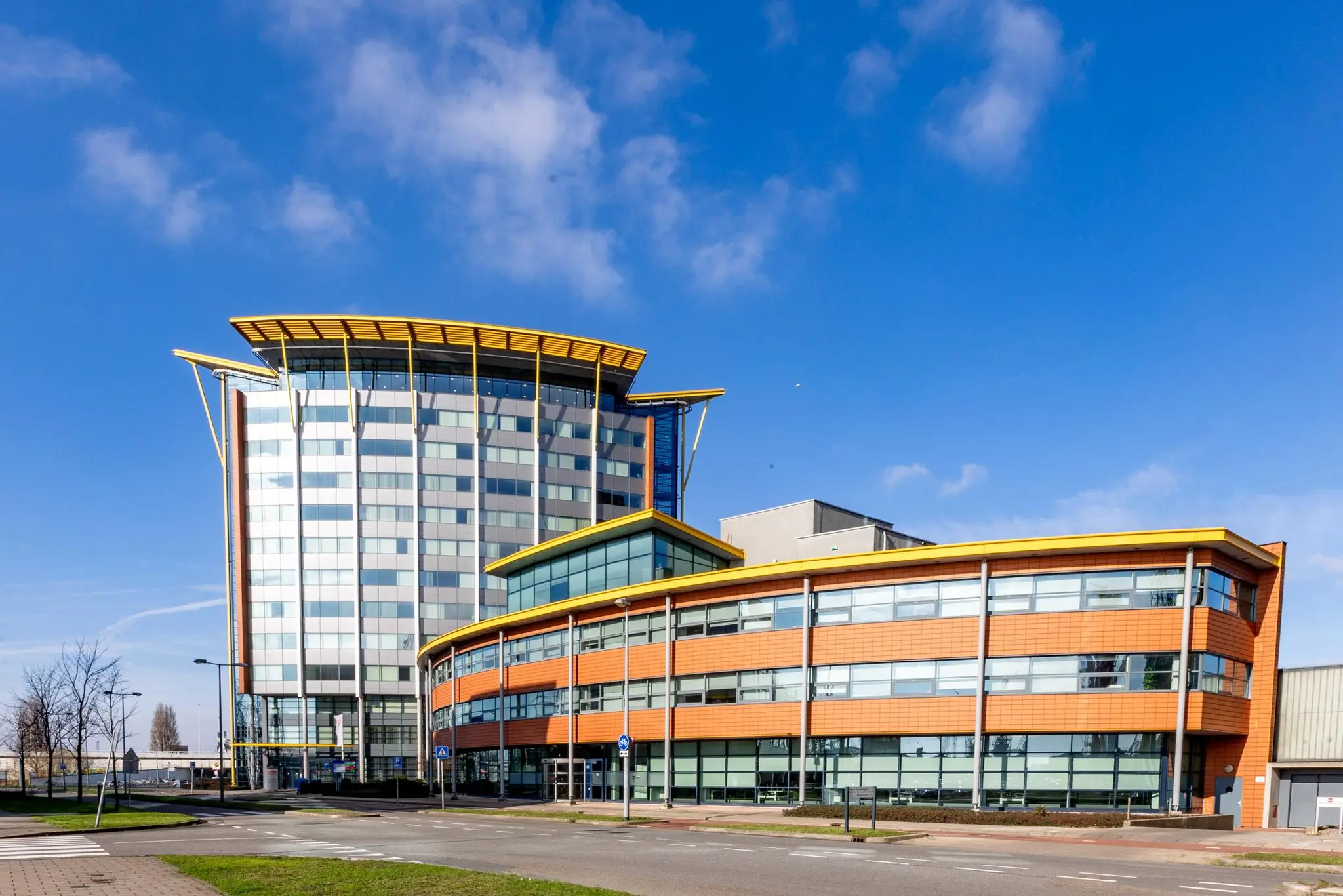 Modern kantoorgebouw aan de Karel Doormanweg met opvallende oranje gevelbekleding en gele dakranden.